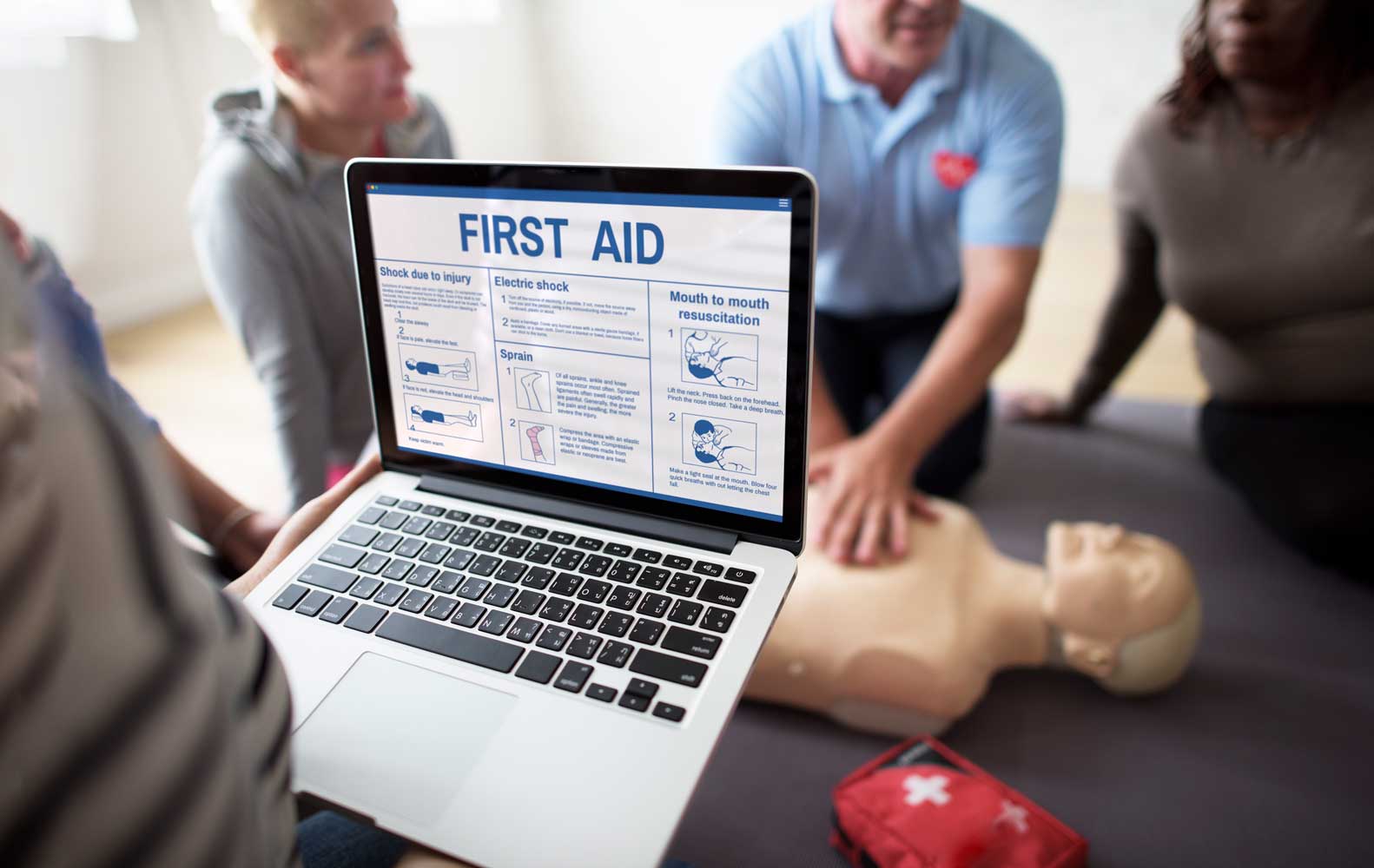An image of a laptop and First Aid training